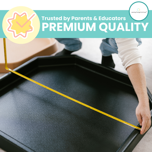 Large black Tuff Tray with textured surface being measured with a tape for premium quality sensory play.