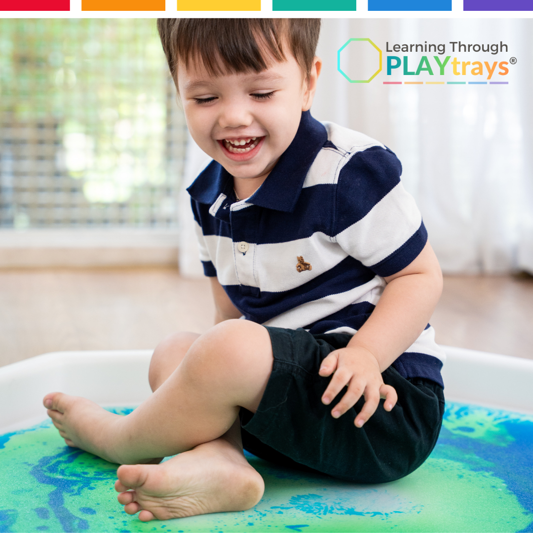 Child playing with a colorful tray, promoting learning through play.